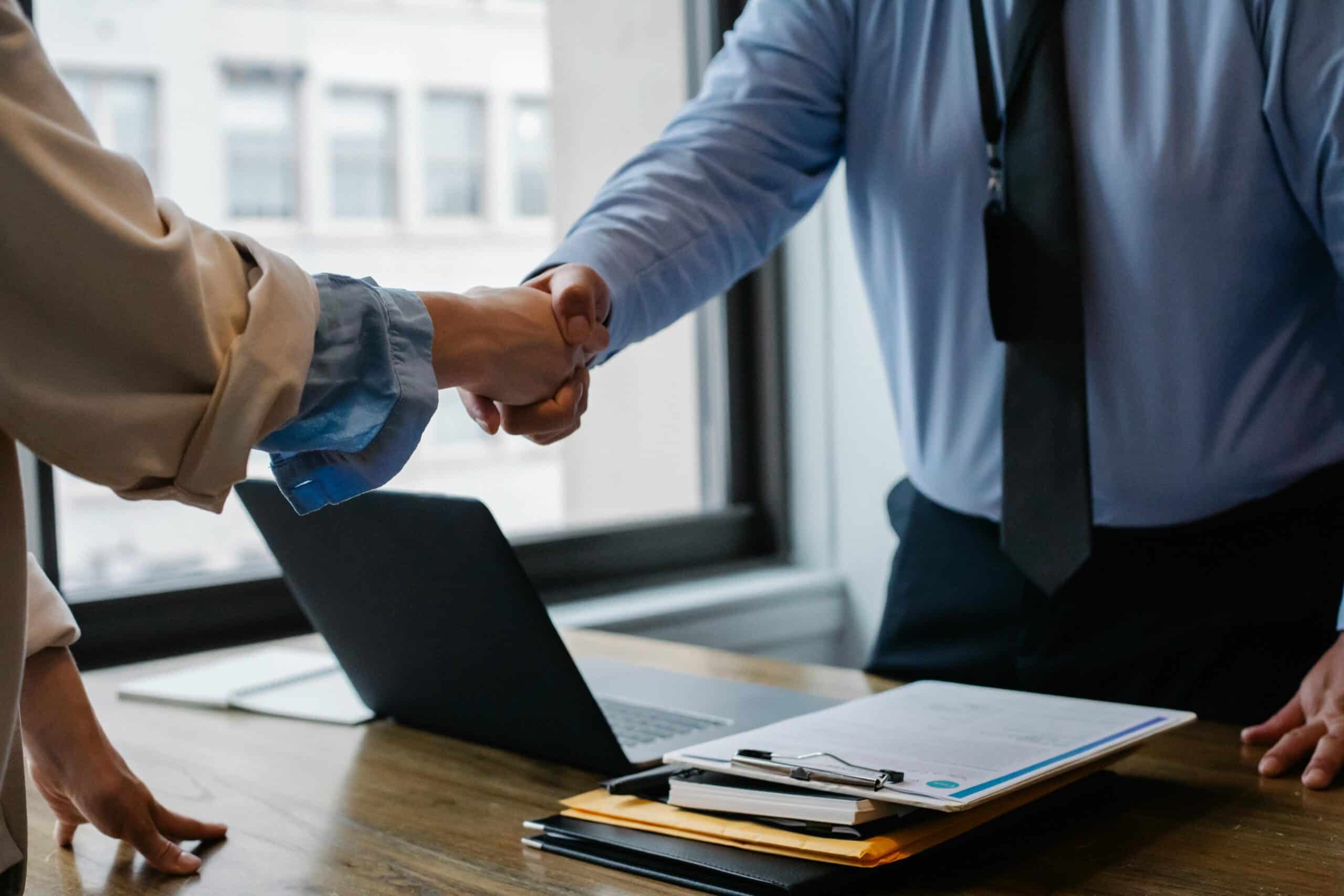 Client and advisor sealing a property investment partnership with a handshake